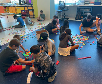 Students working in groups on the floor in a classroom